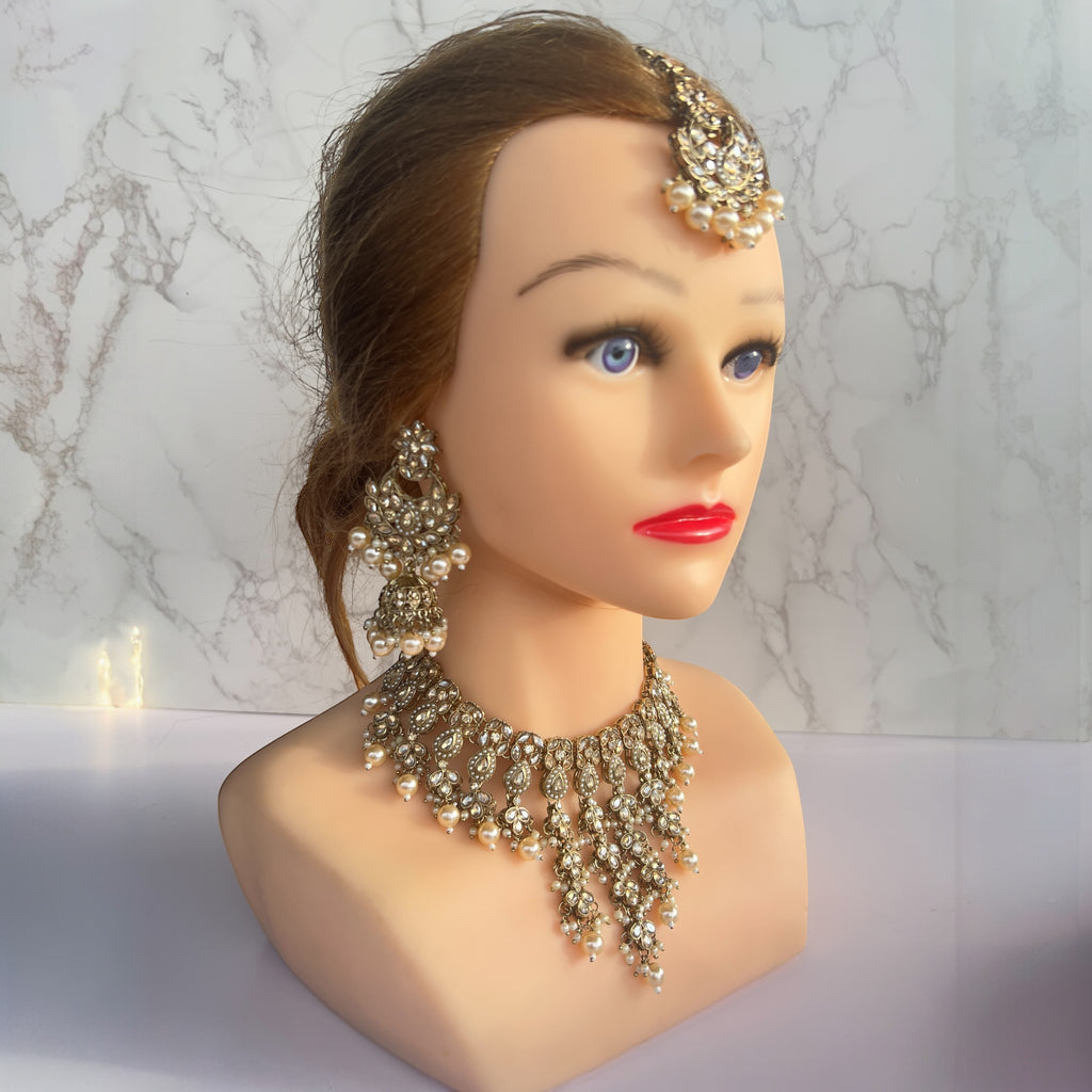 Gold necklace with jhumka earrings and tikka 